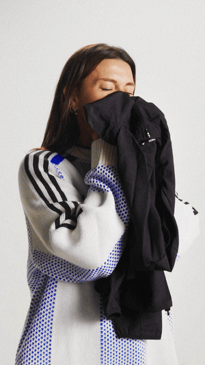 Woman gladly smelling her technical apparel after washing it with the DFNS Sportswear Wash detergent.